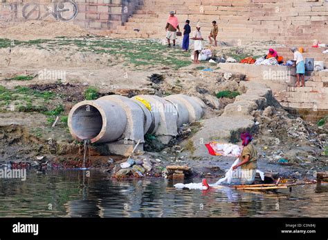 India - Varanasi - River Ganges - sewage pipe and laundryman Stock Photo: 36732098 - Alamy