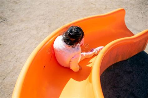 A Child Playing on a Slide at a Playground. Stock Photo - Image of ...