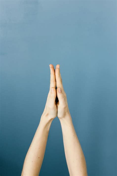 Hands Clasped Against Blue Background · Free Stock Photo