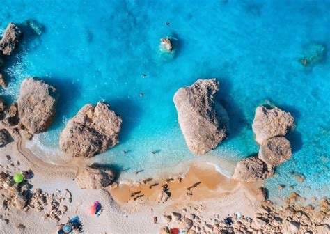 Aerial view of blue sea, beach with umbrellas, rocks in water | Nature ...