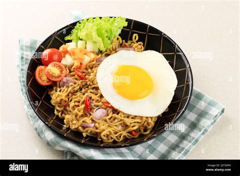 Indomie Goreng or Mie Goreng, Indonesian Popular Instant Noodle. Served with Sunny Side Egg ...