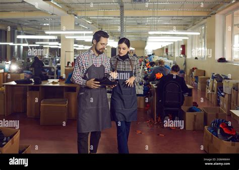 Shoe factory workers looking at leather boot and discussing quality of new footwear Stock Photo ...