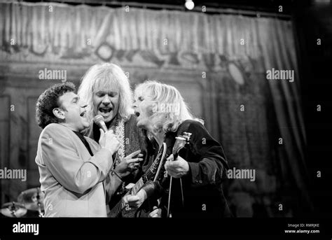 Band members of the rock band Styx are shown performing on stage during a "live" concert ...