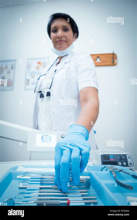 Female dentist picking dental tools Stock Photo - Alamy