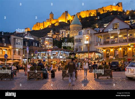 Illuminated tbilisi castle at night with the old town hi-res stock ...