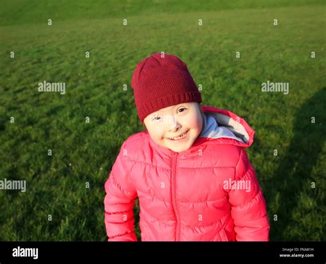 Little girl smiling on background of the green grass Stock Photo - Alamy