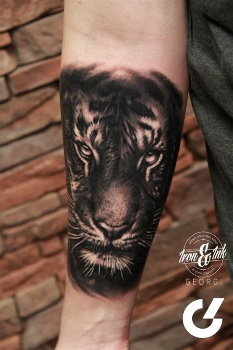 Black and grey tiger tattoo on the forearm.