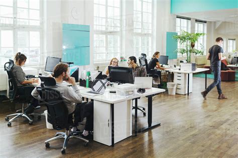 Business people working at desks in creative office - Stock Photo - Dissolve