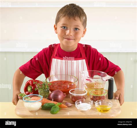 Boy holding the ingredients for tomato soup Stock Photo - Alamy