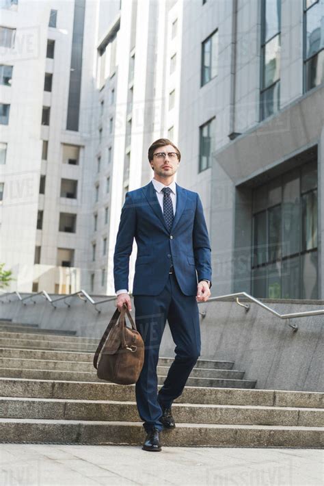 Handsome young businessman in stylish suit with briefcase in business ...