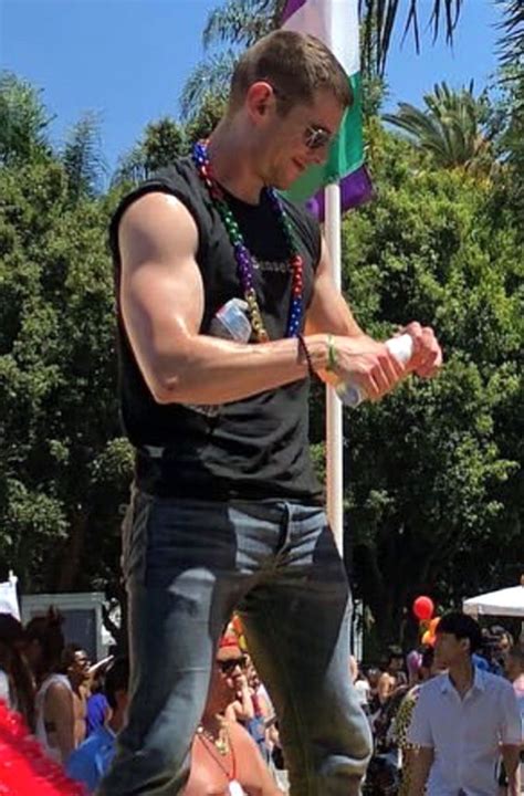 a man standing on top of a flag pole in front of a group of people