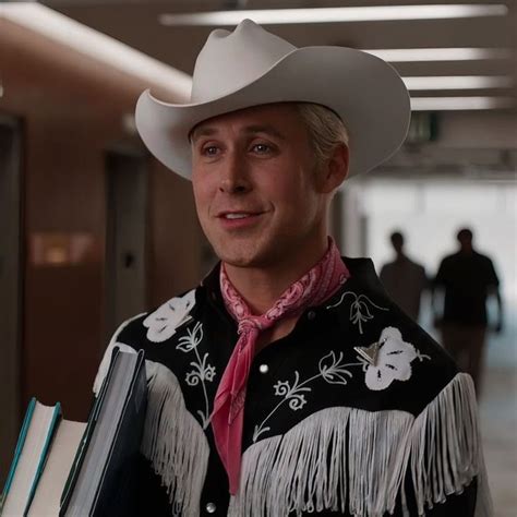 a man wearing a cowboy hat and holding books in an office building with other people