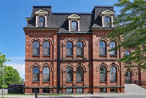 large old fashioned brick building with mansard roof and dormer windows, school or office ...