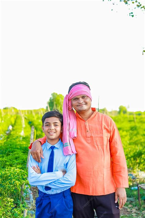 Premium Photo | Cute indian farmer child in school uniform with his father at agriculture field