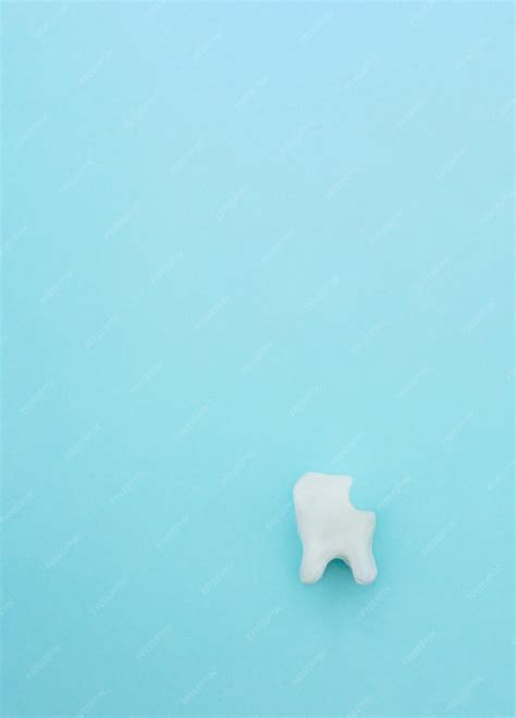 Modelo molar branco de dente não saudável em fundo azul pastel sinal de símbolo de dente cáries ...