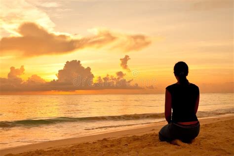 Woman Sitting On A Sand Beach In Front Of Sunset Royalty Free Stock Images - Image: 18963269