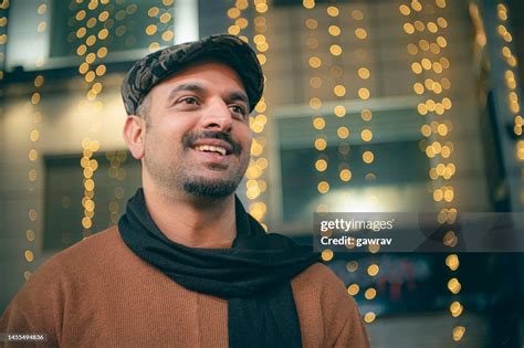 Happy Man Stands Against A Building Decorated With String Lights High-Res Stock Photo - Getty Images