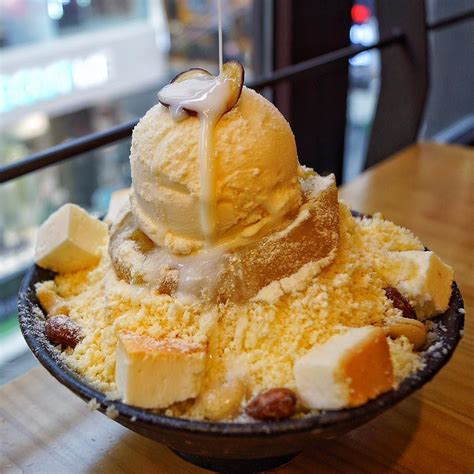 Sweet potato patbingsu(Korean shaved ice) with cheesecake cubes assorted nuts and vanilla ice ...