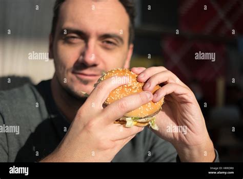 Man eating an hamburger in a fast food Stock Photo - Alamy