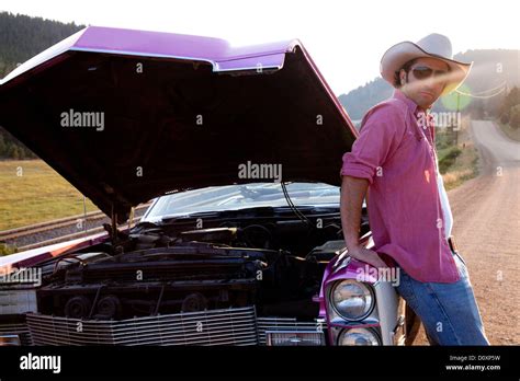 Man leaning against vintage car with hood up Stock Photo - Alamy