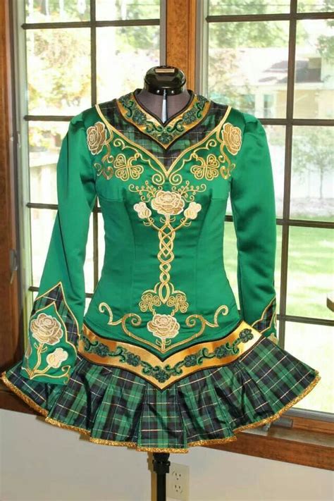 a green and gold dress on display in front of a window