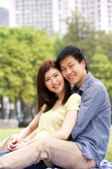 Young Chinese Couple Relaxing In Park Together — Stock Photo © monkeybusiness #24446151