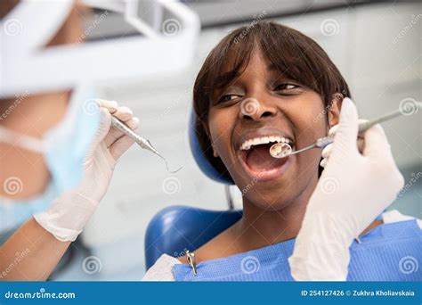 African American Woman Sitting with Open Mouth in Dentist Chair Stock ...