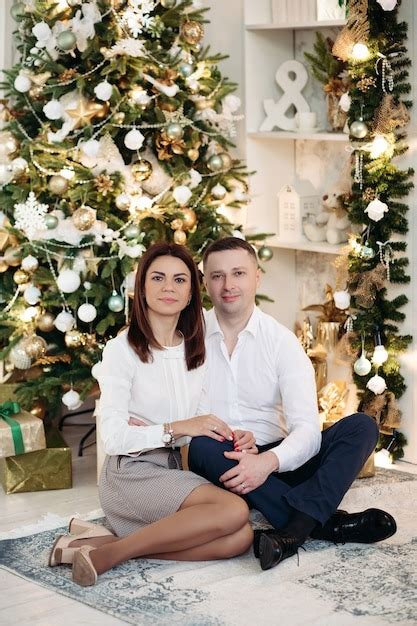 Premium Photo | Couple posing next to christmas tree