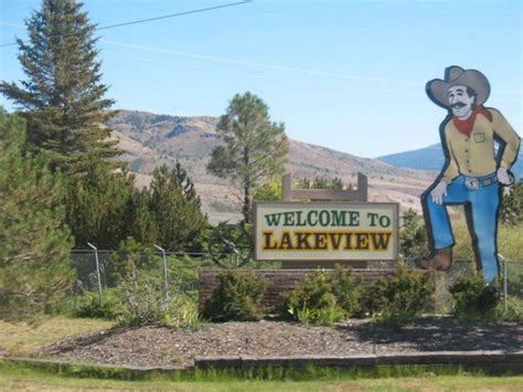 a welcome sign to lakeview with a cowboy on it's back and mountains in the background