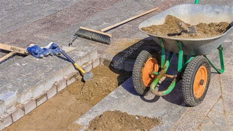 Tool for laying paving slabs on a background of granite bricks and sand-cement mixture — Stock ...