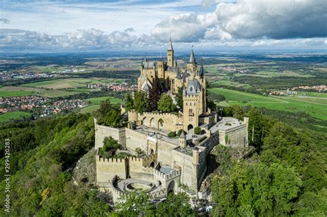 Aerial panorama of Burg Hohenzollern (Hohenzollern castle) with hills and villages surrounded by ...