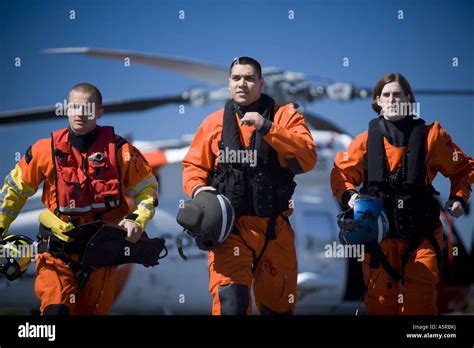 Coast guard workers in uniforms with helicopter Stock Photo - Alamy