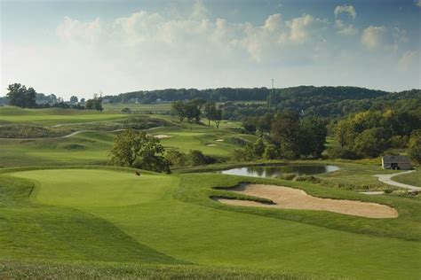 a golf course with water and trees in the background