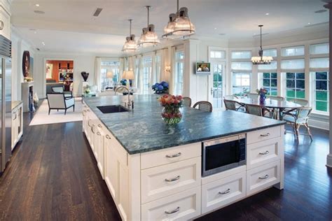 a large kitchen with an island in the middle and lots of windows on both sides