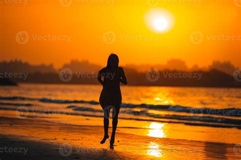 Adorable happy little girl on white beach at sunset. 17951513 Stock Photo at Vecteezy