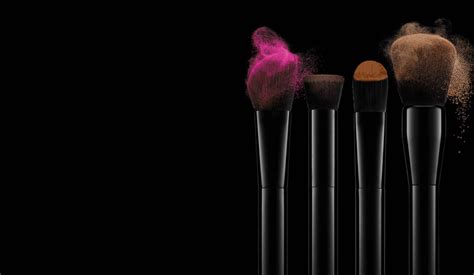 Brushes with coloured make-up on a dark background