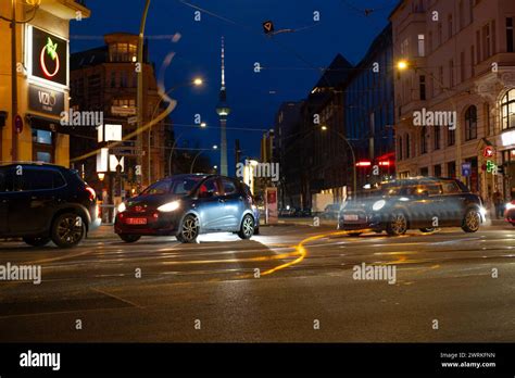 Cars driving down night Oranienburger street, Illuminated buildings and Fernsehturm TV tower ...