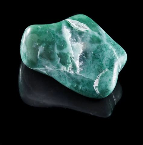 Jadeite mineral stone close up with reflection on black surface | Jewelry Guide