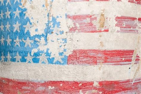 an old american flag painted on the side of a building with paint peeling off it