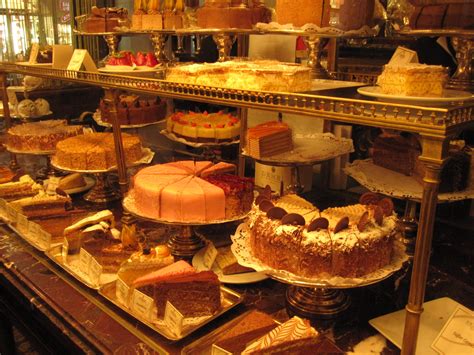 a display case filled with lots of different types of cakes and pies on ...