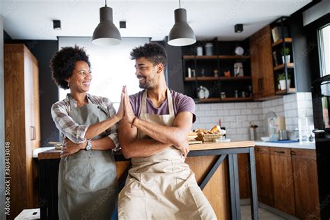 Beautiful young couple cooking healthy food together at home. Having ...