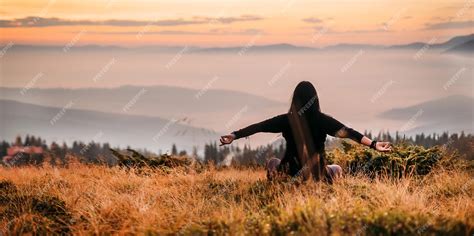 Premium Photo | Yoga woman sitting on top of a mountain at sunrise mountains in the fog the view ...