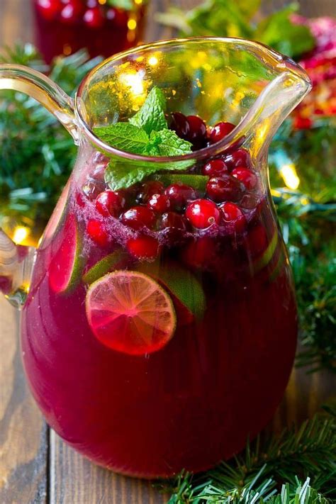 Christmas punch in a pitcher garnished with fresh cranberries, limes ...