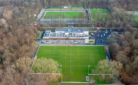 Aerial photo of football pitches surrounded by trees with a building and parking lot - Creative ...