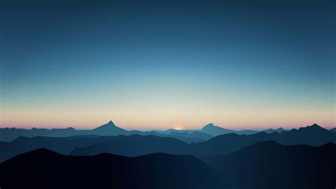 Download A Mountain Range At Sunset With Mountains In The Background Wallpaper | Wallpapers.com