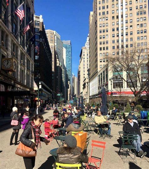 many people are sitting and walking in the city