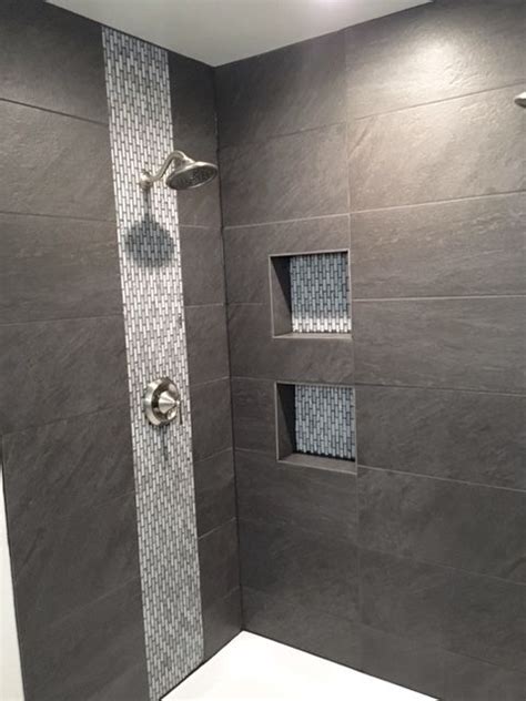 Shower with large field tile. Mosaic tile used for "waterfall" detail and in shampoo nic ...