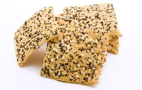 sesame seed crackers stacked on top of each other with black and white sprinkles