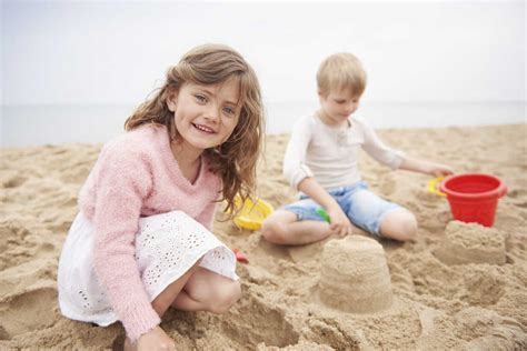 Children building sand castle on beach stock photo