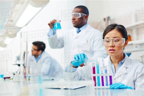 Three scientists working together in a laboratory - Stock Photo - Dissolve